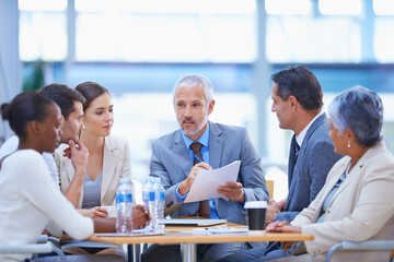 Taking a look at the costs and benefits. A cropped shot of a diverse group of businesspeople having...