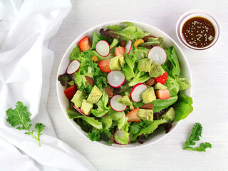 Green lettuce salad with fresh vegetables isolated on white background.