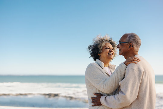 Retired senior couple smiling happily at the beach