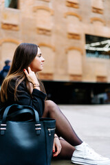 Happy Successful Businesswoman Holding a Takeaway Coffee Cup and smartphone on the Street Next to a park