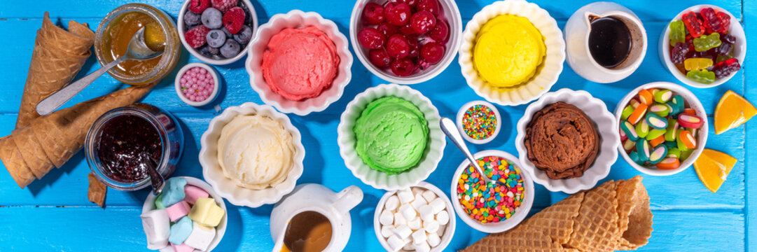 Ice cream festival background, Summer ice cream buffet with various gelato sundaes flavors. sweet toppings and sprinkles, high-colored blue wooden background to view copy space