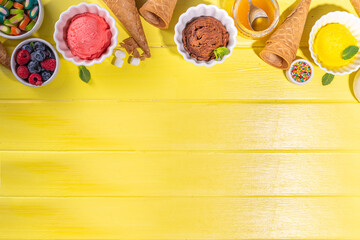 Ice cream festival background, Summer ice cream buffet with various gelato sundaes flavors. sweet toppings and sprinkles, high-colored yellow wooden background to view copy space