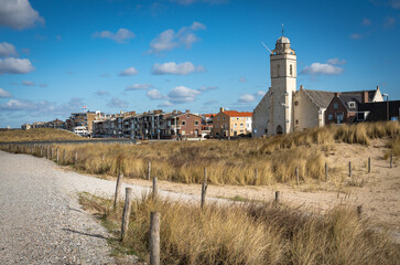 Seaside resort Katwijk aan Zee in The Netherlands, view of white church and walkways along sand...