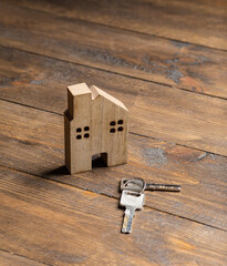 house and key on a wooden surface top view / apartment rental