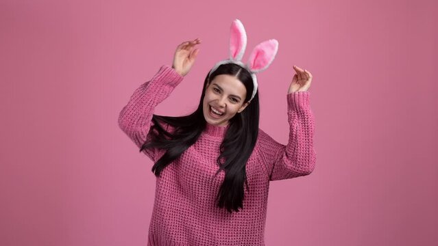 Nice lady showing easter bunny game isolated on pastel color background