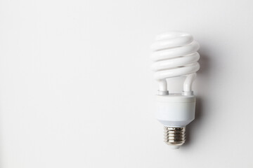 Spiral white light bulb. Energy saving fluorescent light bulb on white background. Green concept. 