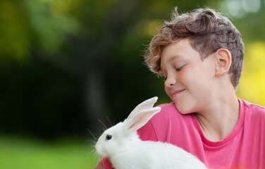 the boy is quite looking at the rabbit on his hands