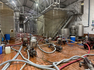 Robertson, Western Cape, South Africa. 2023.  Fermentation tanks in a wine cellar being cleaned...