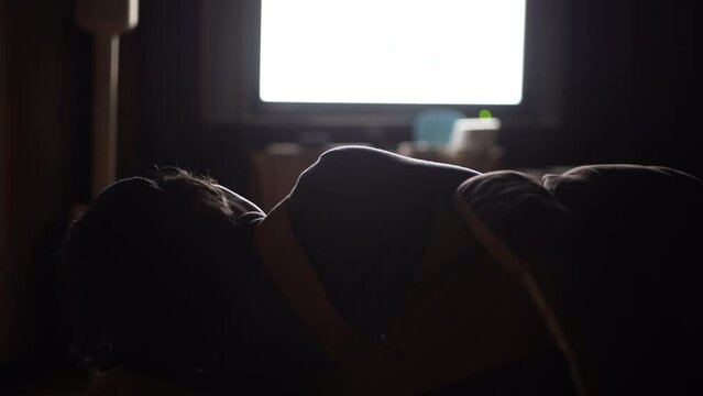 テレビをつけたまま眠る女性
