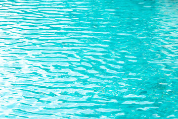 Ripple Water in swimming pool with blue tile floor background