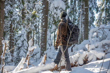 Hiker in snowy forest in winter