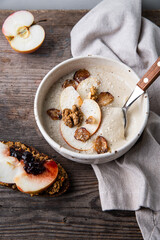 Bowl of homemade Jerusalem artichoke and apple cream soup and toast with homemade pate with fresh apple and cherry jam on wooden table.
