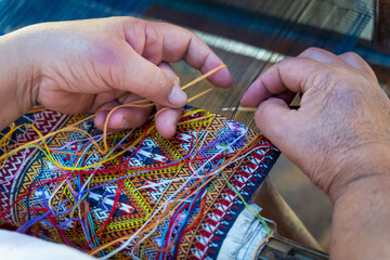 Women hand weave traditional fabrics and textiles technique locally with unique craftsmanship and the famous sarong popular product as a souvenir in Mae Chaem District, Chiang Mai, Thailand.