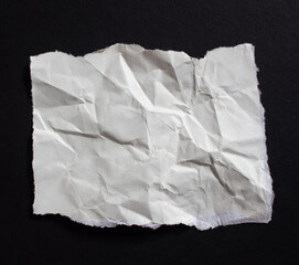 Obraz premium Crumpled torn paper piece isolated on a black background. Ripped paper sheet.