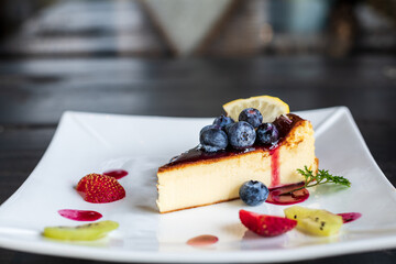 Cheesecakes with fresh berries and strawberry in the plate.
