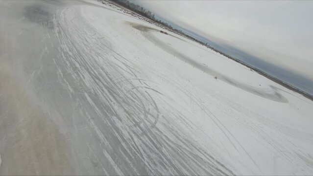 drift on a frozen lake in winter on ice and snow colorful beautiful cars drive sideways competitions, vaz bmw mercedes, flight on an FPV drone behind the car