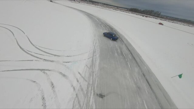 drift on a frozen lake in winter on ice and snow colorful beautiful cars drive sideways competitions, vaz bmw mercedes, flight on an FPV drone behind the car