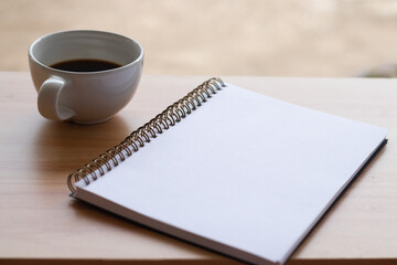 Blank notebook for writing and coffee cup
