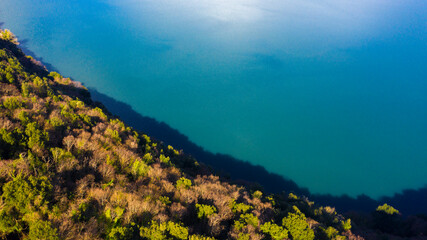 Aerial view over the Lake Albano in Rome, Italy. Autumn colors dye the trees along the river.