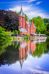 Fototapeta na wymiar Bruges, Belgium. Minnewater, tranquil lake with lush greenery in romantic