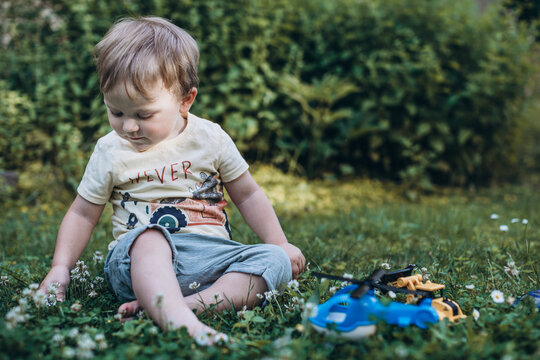 little boy playing cars in the park