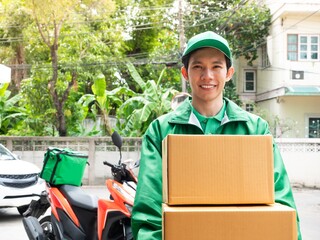 Asian delivery man holding postal box es after rode motorcycle for shipping e-commerce order...