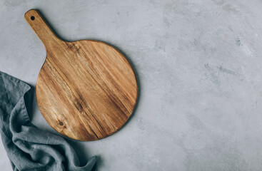 Fototapeta na wymiar Chopping board. Empty round wooden cutting board with napkin on gray stone background
