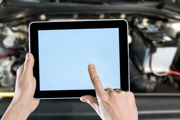 Auto mechanic hands works on digital tablet