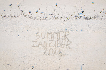 Etched into the sand of Zanzibar's vacation beach is a captivating inscription.