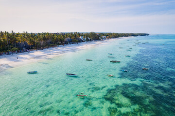 Behold the breathtaking aerial footage of Zanzibar's Kiwengwa beach, a tropical paradise with swaying palms and crystal-clear waters