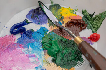 A palette of paints of different colors. Acrylic paints