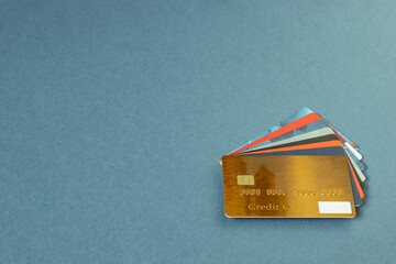 Gold color credit card, gift cards, discount cards, fan sales cards lie on a blue background. Pile of credit cards for different purposes