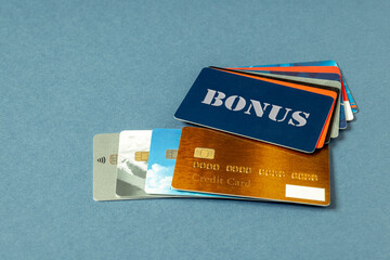Credit cards of different issuers, BONUS card, fan sales cards lie on a blue background. Pile of...