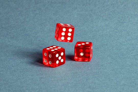 Random number generator. Three red dice with numerical values lie in a chaotic order.
