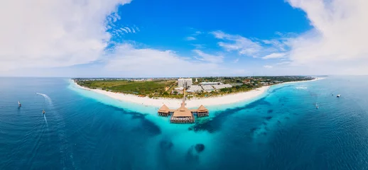 Zelfklevend behang Nungwi Strand, Tanzania From above, the stunning beauty of Zanzibar's Nungwi Beach is captured in an aerial view with a yacht and palm trees on the sandy beach.