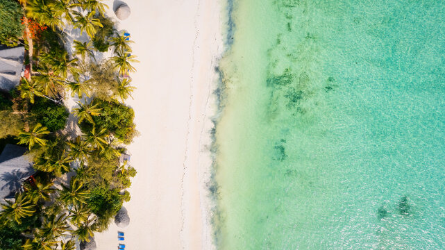 From above, the stunning beauty of Zanzibar's Nungwi Beach is captured in an aerial view with a yacht and palm trees on the sandy beach. © Sebastian