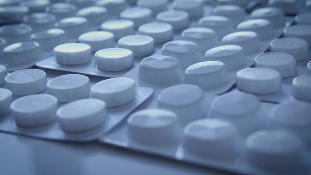 White blisters with tablets lying on table, clinical trials of existing drugs analogues, packages with active ingredients and placebo, risk group