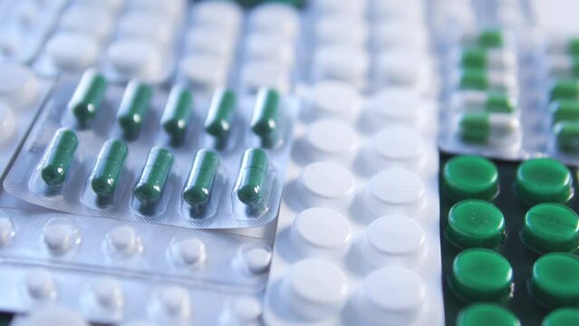 Many white and green pills and tablets lying on table, big choice of hormonal drugs for women, normalization of hormonal levels before pregnancy planning, progesterone, estradiol, prolactin