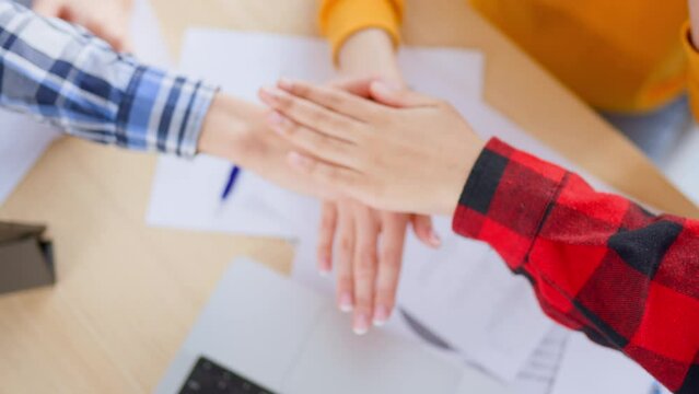 Colleagues put hands together on top of each other, say motto motivational speech to raise team spirit and hands up. Teamwork in office. Trust, support, cooperation, help, common goal, unity people.