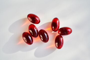 Red krill oil capsules on a bright background