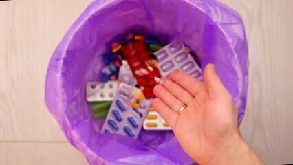 throws medicine pills into the trash.