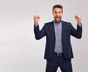 Celebrations are in order. Portrait of a handsome young man with his arm raised in triumph.