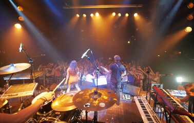 A band playing on stage at a concert- This concert was created for the sole purpose of this photo shoot, featuring 300 models and 3 live bands. All people in this shoot are model released