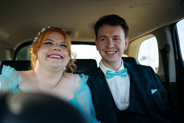 Candid portrait of young couple of newlyweds inside car. Wedding or prom photo. © Maria