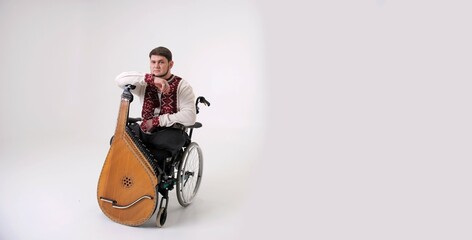 invalid handsome young man with kobza musical instrument in hands sits on white background on...
