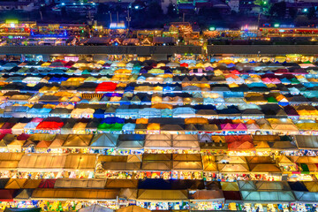 Colorful rows of outdoor market tents and food stalls at night, Asia. 