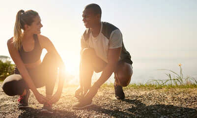 Grab your workout buddy and go. Shot of a fit young couple tying their shoelaces before a run...