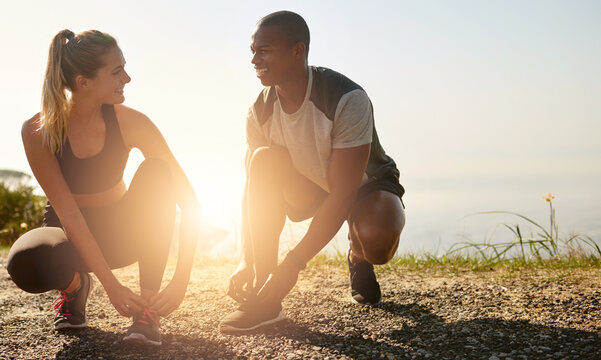 Grab your workout buddy and go. Shot of a fit young couple tying their shoelaces before a run outdoors.