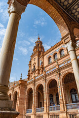 Perspective of blurred column with arch framing palace tower in Plaza de España, Seville SPAIN