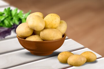 Fresh raw potato in on wooden desk